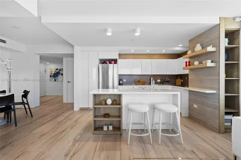 a kitchen with stainless steel appliances kitchen island a table and chairs in it