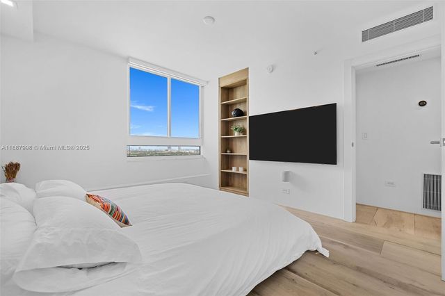 a bedroom with a bed and a flat screen tv