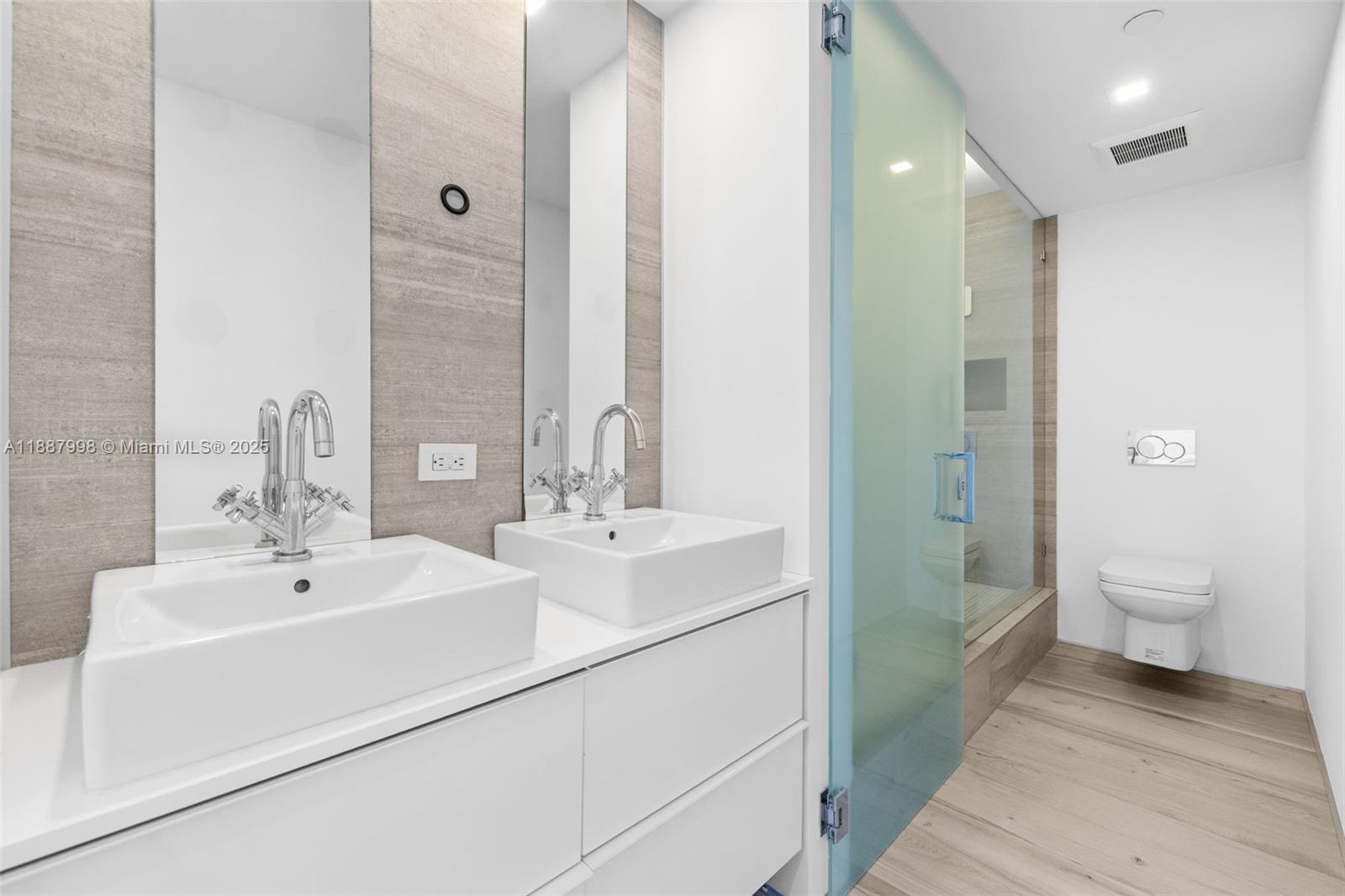 1330 West Avenue, Unit 3407 Miami Beach, FL 33139 - Photo 23 of 42 a bathroom with a double vanity sink toilet and a shower