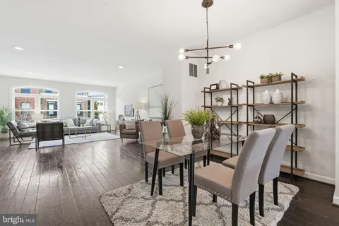 a dining room with furniture a chandelier and wooden floor