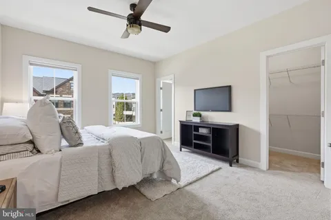 a living room with a bed furniture and a flat screen tv