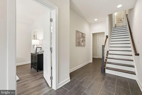 a view of a hallway with entryway and stairs