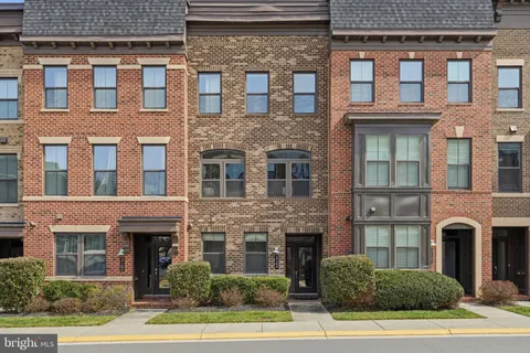 a front view of a building with a garden and plants