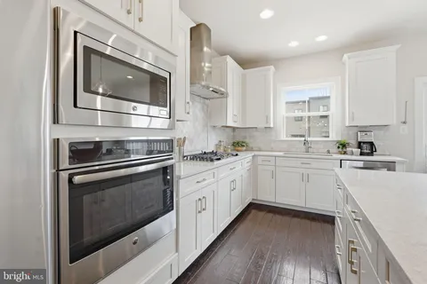 a kitchen with granite countertop white cabinets stainless steel appliances and sink