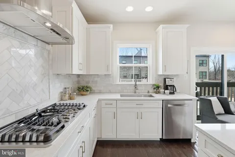 a kitchen with white cabinets and appliances