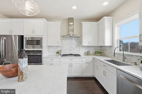 a kitchen with stainless steel appliances a stove sink and cabinets