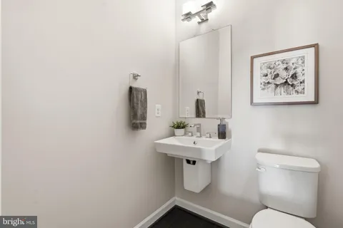 a bathroom with a toilet a sink and mirror