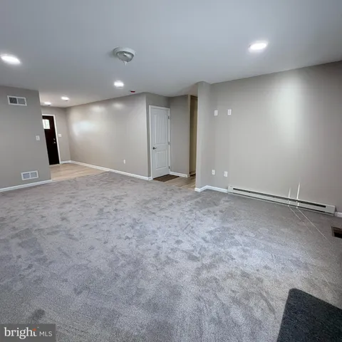 a view of an empty room with a chandelier fan