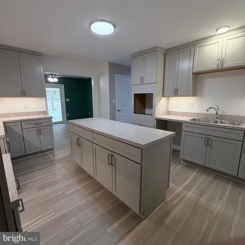 an empty room with windows and ceiling fan