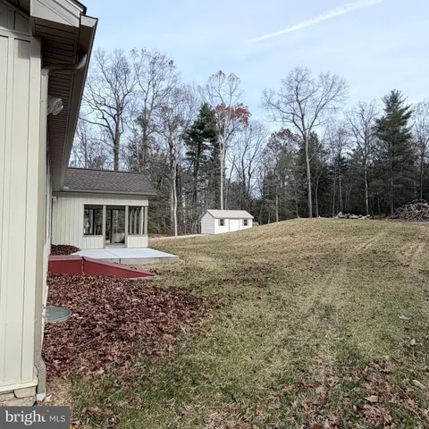 a view of house with backyard and trees