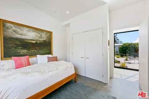 a bedroom with a bed and a large window