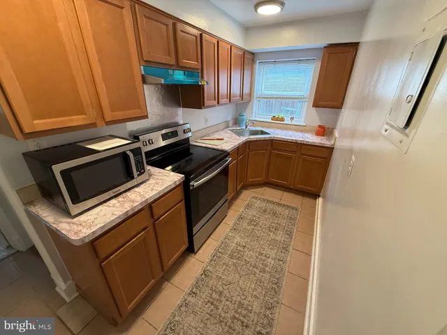 a kitchen with stainless steel appliances a stove a sink and a microwave