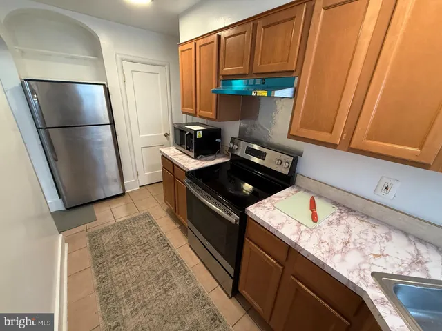 a kitchen with stainless steel appliances granite countertop a refrigerator stove and a sink
