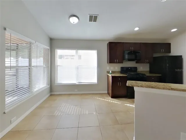 a kitchen with stainless steel appliances granite countertop a stove a sink a microwave a refrigerator and cabinets