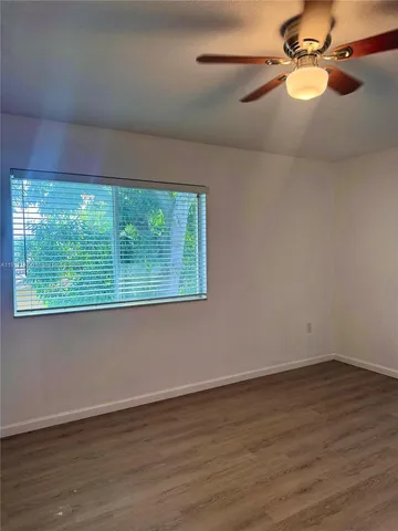 a view of room with window and wooden floor