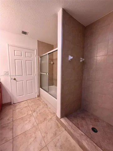 a bathroom with a granite countertop sink a mirror and a shower