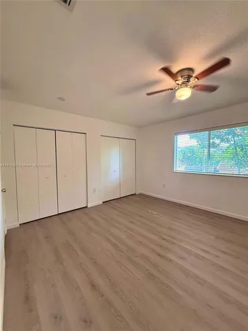a view of a hallway with wooden floor and stairs
