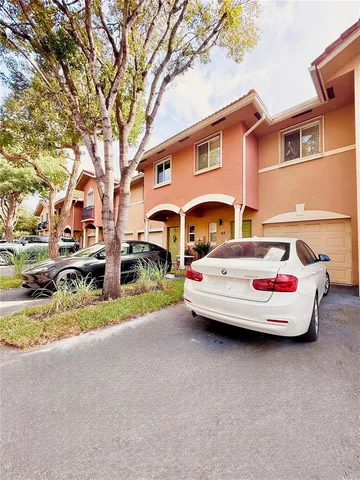 a front view of a house with a garden and parking