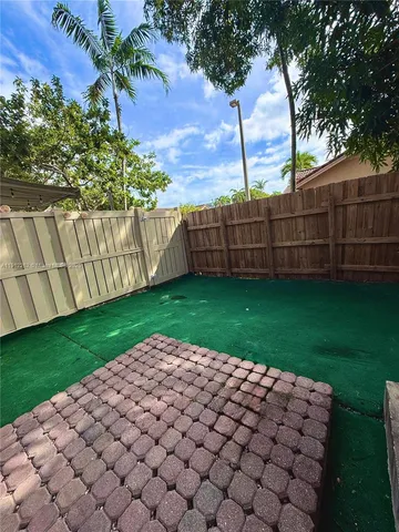 a view of a yard with wooden fence