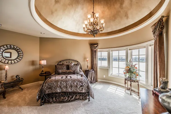 a bedroom with a bed and a chandelier