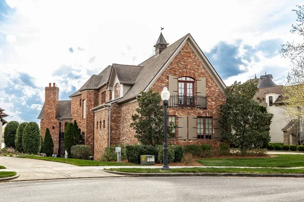 a view of a big house with a yard and plants