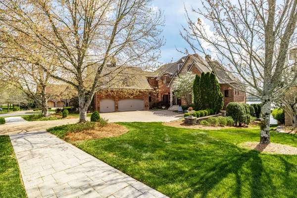 an aerial view of a house with outdoor space and lake view in back