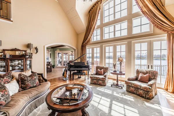 a living room with furniture a fireplace and large windows