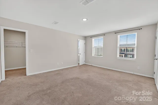 an empty room with closet and a ceiling fan