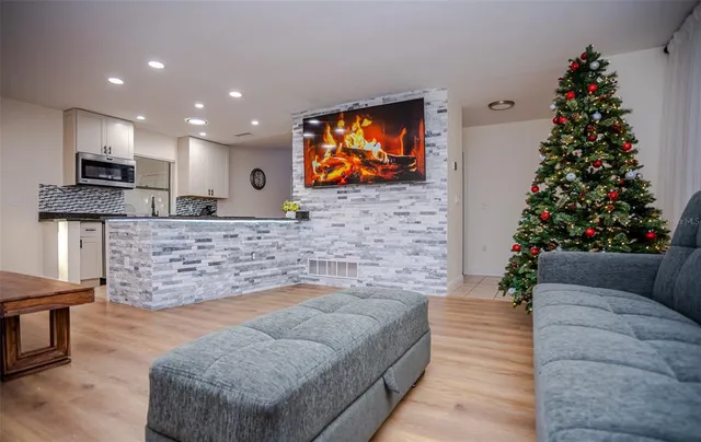 a living room with fireplace furniture a potted plant and a fireplace