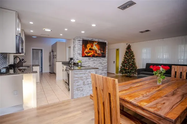a kitchen with stainless steel appliances kitchen island granite countertop a stove a sink a refrigerator and microwave