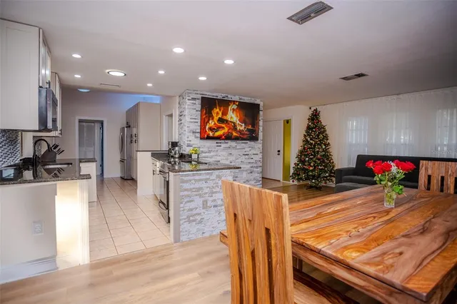 a kitchen with stainless steel appliances kitchen island granite countertop a stove a sink a refrigerator and microwave