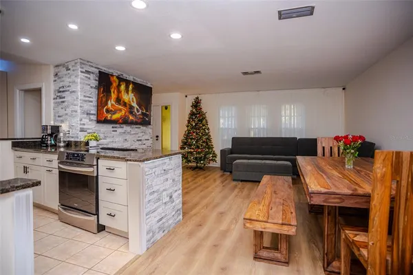 a kitchen that has a lot of cabinets in it and wooden floor