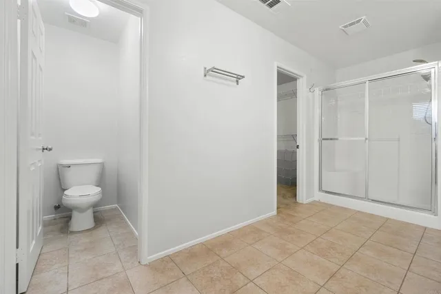 a view of an empty room with a chandelier fan