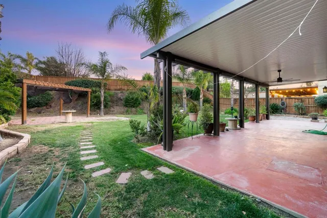 a view of a patio with a table and chairs under an umbrella
