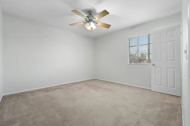 a view of an empty room with a ceiling fan