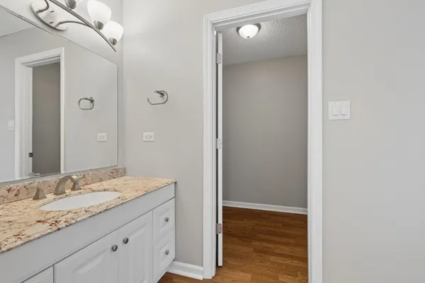 a bathroom with a granite countertop sink and a mirror