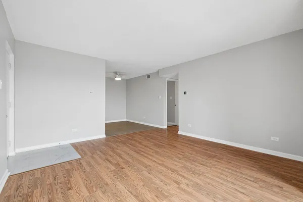 a view of an empty room with wooden floor