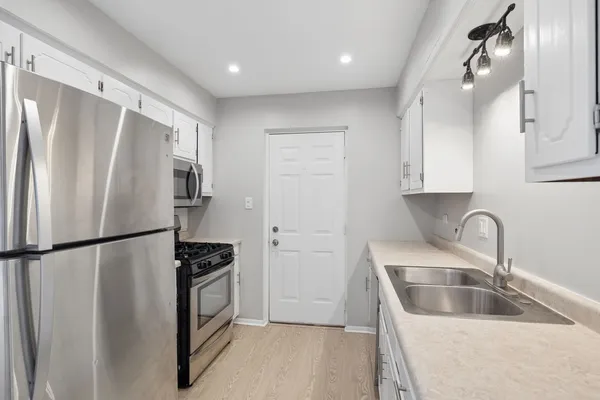 a kitchen with a refrigerator a sink and cabinets