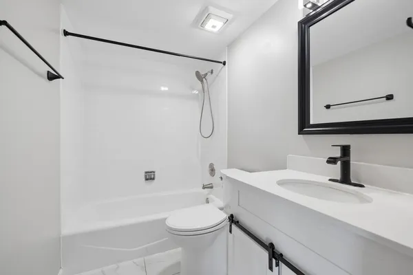 a bathroom with a sink a toilet and shower