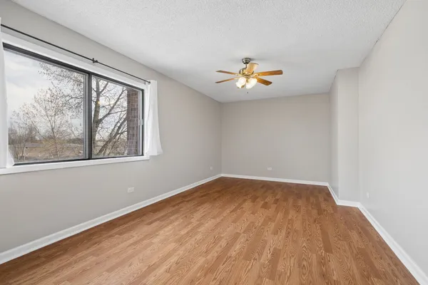 an empty room with a window and a ceiling fan