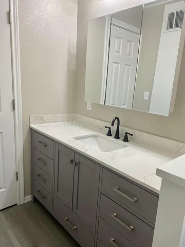 a view of a kitchen with stainless steel appliances granite countertop a sink and cabinets