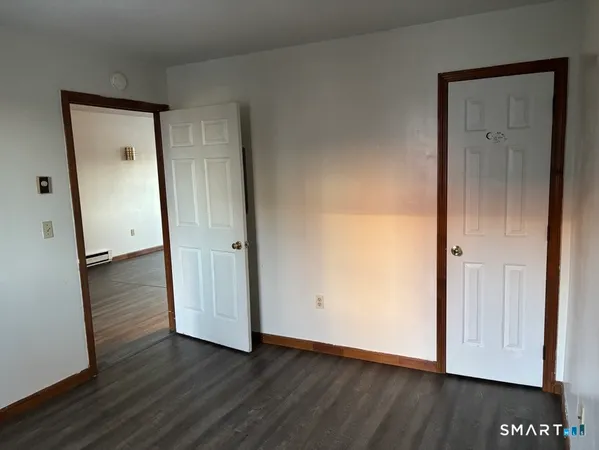 an empty room with wooden floor and mirror