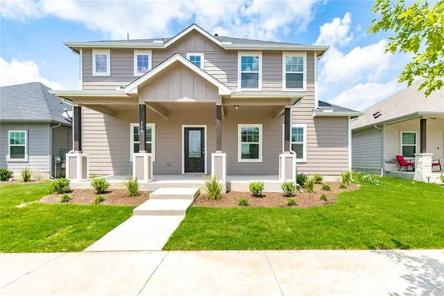 a front view of a house with a yard and plants