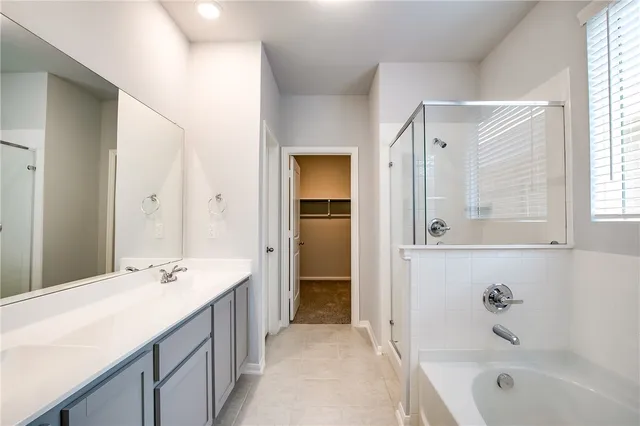 a bathroom with a bathtub shower and a sink