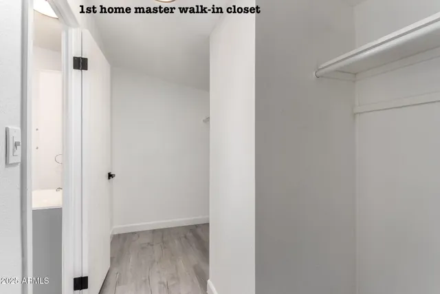 a view of an empty room and chandelier fan