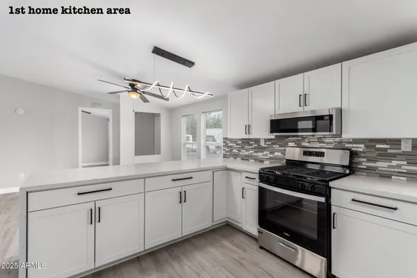 a kitchen with cabinets stainless steel appliances and wooden floor