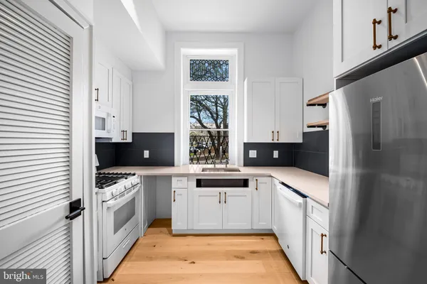 a kitchen with stainless steel appliances a stove a sink and a refrigerator