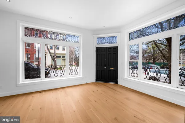 a big room with wooden floor and a floor to ceiling window