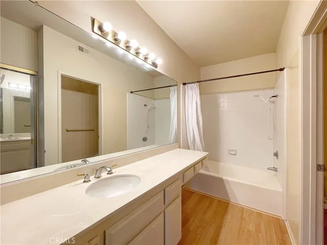 a bathroom with a granite countertop sink mirror and a bathtub