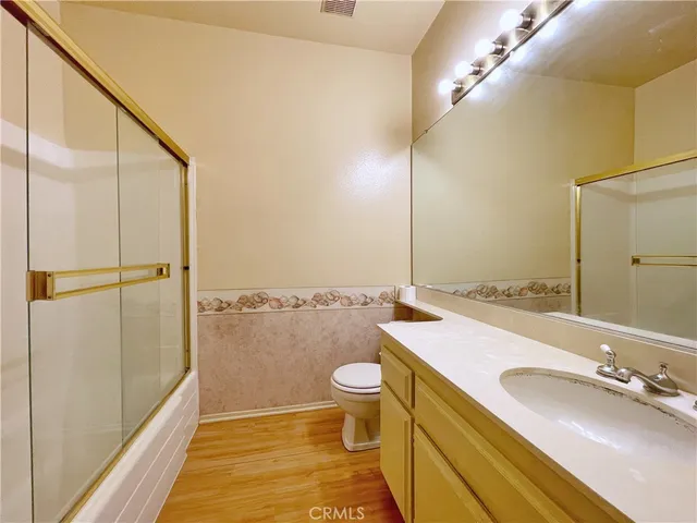 a bathroom with a sink a toilet a mirror and shower